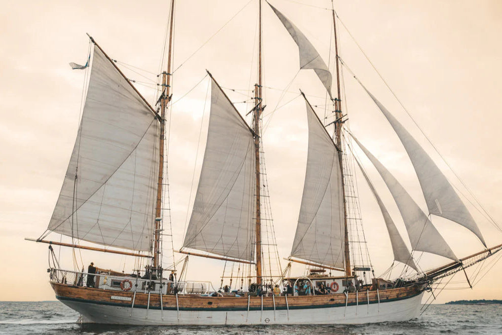 Sailing ship with multiple masts and sails on a body of water